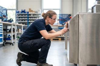 Femme inspectant une machine dans un espace industriel moderne